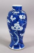 A 19TH CENTURY CHINESE BLUE & WHITE PORCELAIN PRUNUS VASE - decorated with a blue ground and with