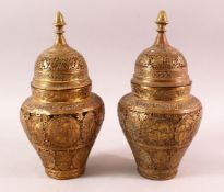 A PAIR OF QAJAR OPENWORK BRASS VASES & COVERS, with roundel figural decoration, 28cm
