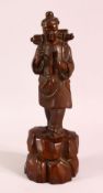A 19TH CENTURY CHINESE CARVED WOODEN FIGURE OF A TRAVELLER, 32cm