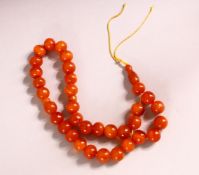 A SET OF 19TH CENTURY CARVED AMBER BEAD NECKLACE - Comprising 34 carved beads, 2 spacers and one