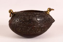 A SMALL ISLAMIC CARVED COCO KASHKOOL, the sides carved with calligraphy, with two brass ring