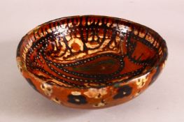 A SMALL PERSIAN BROWN GLAZED TERRACOTTA BOWL, the inner decorated with a stylised bird, 18cm
