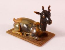 A 19TH CENTURY INDIAN CARVED HORN MODEL OF A RECUMBENT DEER, 12cm long.