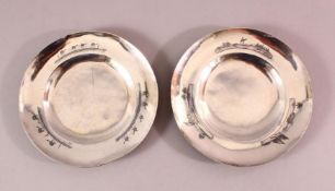 TWO IRAQI SILVER AND NIELLO DECORATED CIRCULAR DISHES, the borders engraved with river lanscapes and
