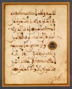 A FRAMED AND GLAZED KUFIC CALLIGRAPHIC MANUSCRIPT PAGE, double-sided, glazed on both sides,