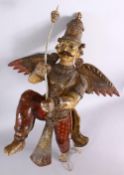 A 19TH CENTURY INDIAN / BURMESE CARVED WOOD FIGURE OF A WINGED GOD, stood holding an implement