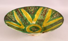 A LARGE NISHAPUR GREEN AND YELLOW GLAZED POTTERY BOWL, 37cm diameter.