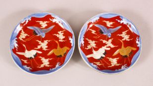 A PAIR OF JAPANESE MEIJI PERIOD FUKAGAWA PORCELAIN DISHES - each with a red ground and three