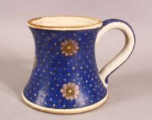 A TURKISH IZNIK POTTERY BLUE & WHITE CUP - decorated with floral rounds, with large handle, 15cm