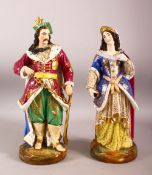 A PAIR OF TURKISH PORCELAIN SULTAN & SULTANA - both in traditional gowns holding objects, 38cm high
