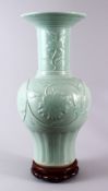 A LARGE CHINESE CELADON PORCELAIN VASE & STAND, the vase decorated with moulded floral decoration,