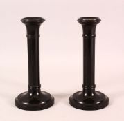 A PAIR OF INDIAN TURNED EBONY CANDLESTICKS, 20cm high.