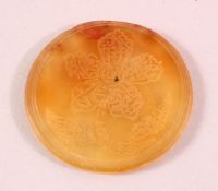 AN ISLAMIC CIRCULAR YELLOW AGATE PLAQUE, with engraved decoration, 6cm diameter.