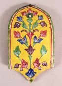 AN INDIAN ENAMELLED TERRACOTTA TILE, the surface with moulded floral decoration, 24cm x 13.5cm.