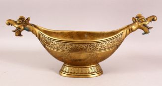 A LARGE INDO PERSIAN BRASS KASHKUL BOWL with dragon head terminals, 45cm long.