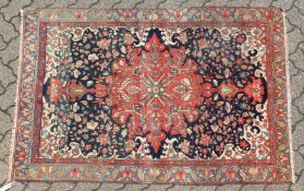 A GOOD MALAYER RUG, red ground with stylised floral decoration within, a pale blue border. 6ft 10ins