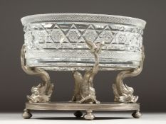 A GOOD ALPACA PLATE OVAL CENTREPIECE with cut glass oval dish on a stand with four dolphin
