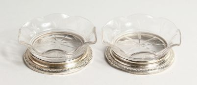 A PAIR OF STERLING SILVER ENGRAVED GLASS DISHES 3.75 ins diameter