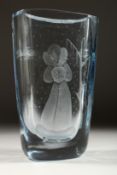 A HEAVY BLUE TINTED SWEDISH VASE etched with a lady standing beside a tree. Signed 10.5ins high.
