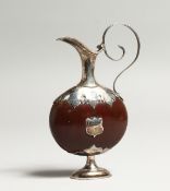 A MINIATURE SILVER MOUNTED EWER, the body formed from a nut or bean. 4ins high