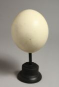 AN OSTRICH EGG, mounted on a circular base 9.5ins high.