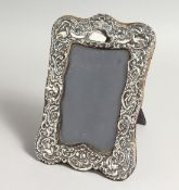 A REPOUSSE SILVER PHOTOGRAPH FRAME with birds 8ins x 5ins