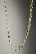 A SILVER FACET CUT PERIDOT LONG CHAIN.