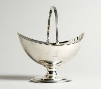 A GEORGE III SILVER BOAT SHAPED SUGAR BASKET, with reeded swing handles, crest. London 1809. Maker