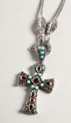 A SILVER TURQUOISE AND GARNET CROSS on a silver chain.