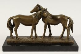 A BRONZE GROUP OF TWO HORSES, “THE ACCOLADE”, on a marble base. 14ins long