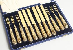 A GOOD SET OF SIX SILVER GILT DESSERT KNIVES AND FORKS, the handles cast with Indian animals and