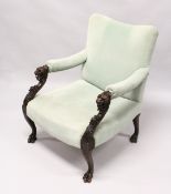A GOOD, POSSIBLY IRISH, MAHOGANY ARM CHAIR with padded back arms and seat. The frame carved with