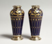 A GOOD PAIR OF LIMOGES BLUE AND GILT PORCELAIN VASES with sliver tops and bases. 4.25ins high.