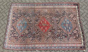A SHIRAZ RUG, with three large central medallions, in a narrow border. 8ft 7ins x 5ft 9ins.