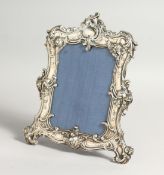 A VICTORIAN PLATE PHOTOGRAPH FRAME with scrolls 9ins x 7ins.