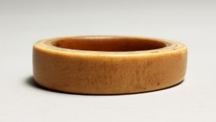 A TRIBAL IVORY BANGLE 3ins.
