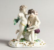 A 19TH CENTURY MEISSEN PORCELAIN GROUP OF TWO PUTTI, one as a scribe (A F one arm missing) 4.5ins