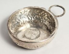 A 19TH CENTURY FRENCH SILVER WINE TASTER inset with an 1850 two Franc coin.