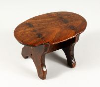 AN EARLY TREEN OVAL STOOL 9ins long, 5.5ins wide, 5ins high Stamped G.F.