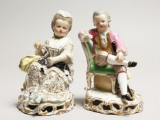 A GOOD PAIR OF MEISSEN PORCELAIN FIGURES, a young man reading a book, a girl sewing. Cross swords
