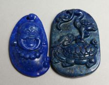 TWO SMALL CARVED LAPIS PENDANTS.