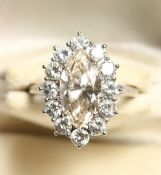 A SUPERB 18CT GOLD CHAMPAGNE DIAMOND SURROUNDED BY TWELVE WHITE DIAMONDS.