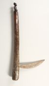 A TRIBAL WOOD AND METAL AXE carved with a figure. 24 ins long.