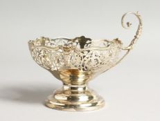 A PIERCED CIRCULAR BON-BON DISH with curving handle London 1917