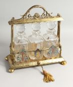 A VERY GOOD VICTORIAN, GILDED PLATE, THREE BOTTLE TANTALUS with acanthus scrolled handles,