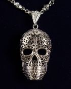 A SILVER SKULL ON A CHAIN.