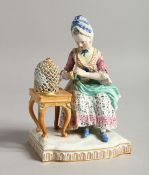 A 19TH CENTURY MEISSEN PORCELAIN GROUP, a seated lady with a bird in a cage. Cross swords mark in