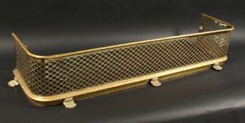 A 19TH CENTURY BRASS FENDER with pierced fretwork front on brass claw feet. 4ft long 11ins deep