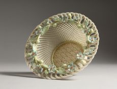 A BELLEEK PORCELAIN CIRCULAR PIERCED BASKET, the rim decorated with flowers. 6ins diameter.