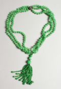 A VERY GOOD STRING OF JADE BEADS with a gold and diamond clasp.